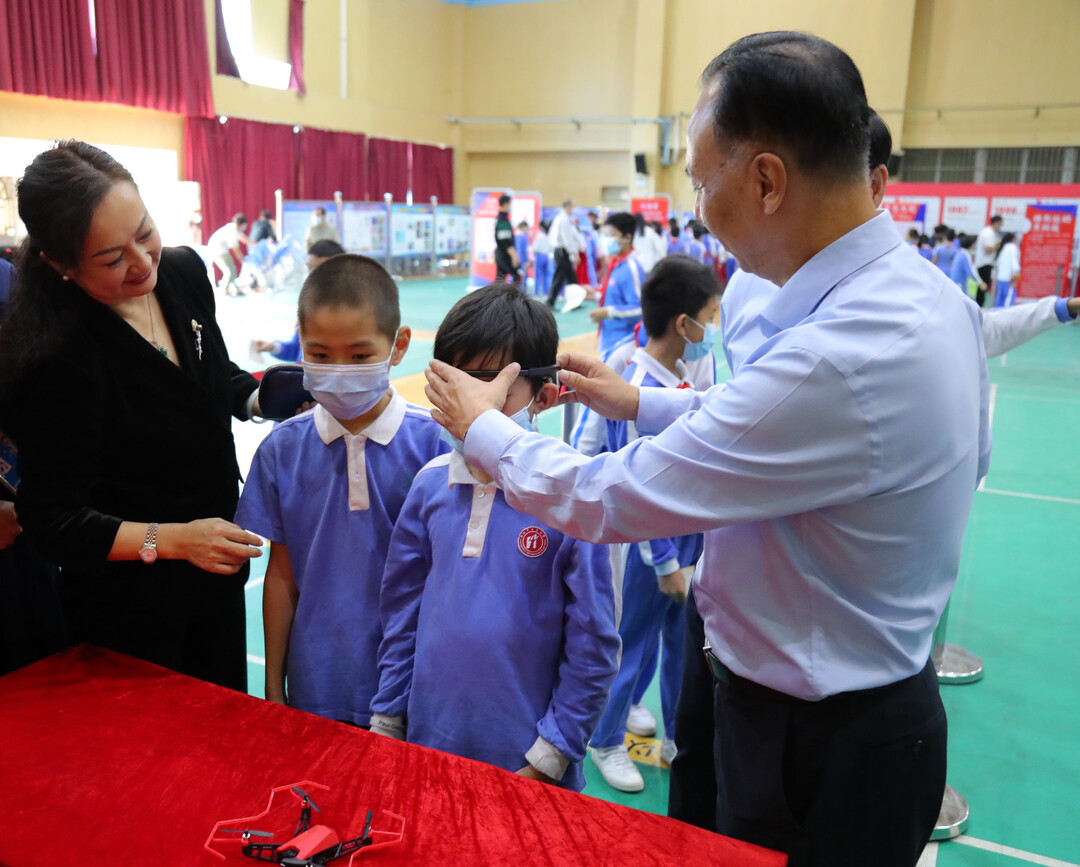 李洪滨校长、杨兵副校长与学生一起体验意念无人机.jpg